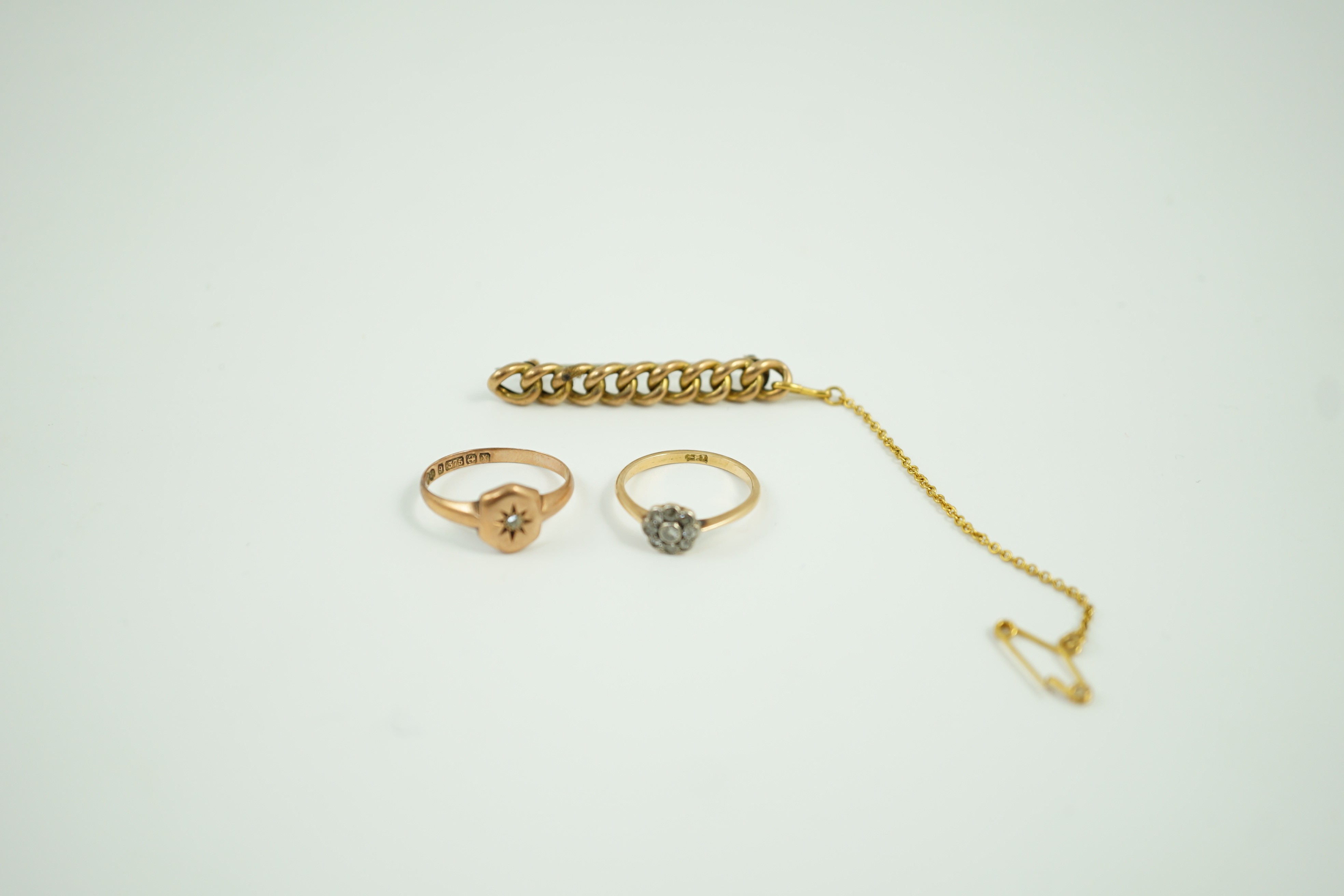 A small 18ct and diamond set cluster ring, size K, gross 1.2 grams, a 9ct gold and diamond chip set ring and a yellow metal curb link bar brooch, gross 5.1 grams.